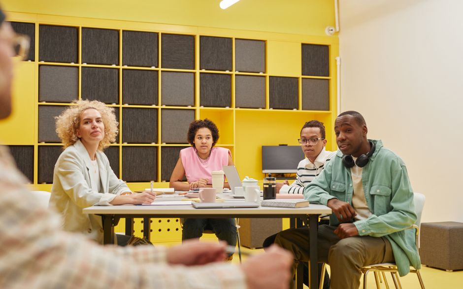 A diverse group of colleagues collaborating in a brightly lit modern office space.