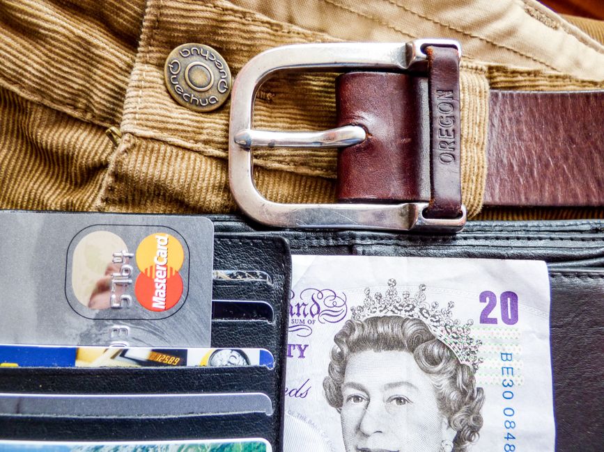 A detailed image of a wallet containing credit cards, a leather belt, and currency, emphasizing personal finance.