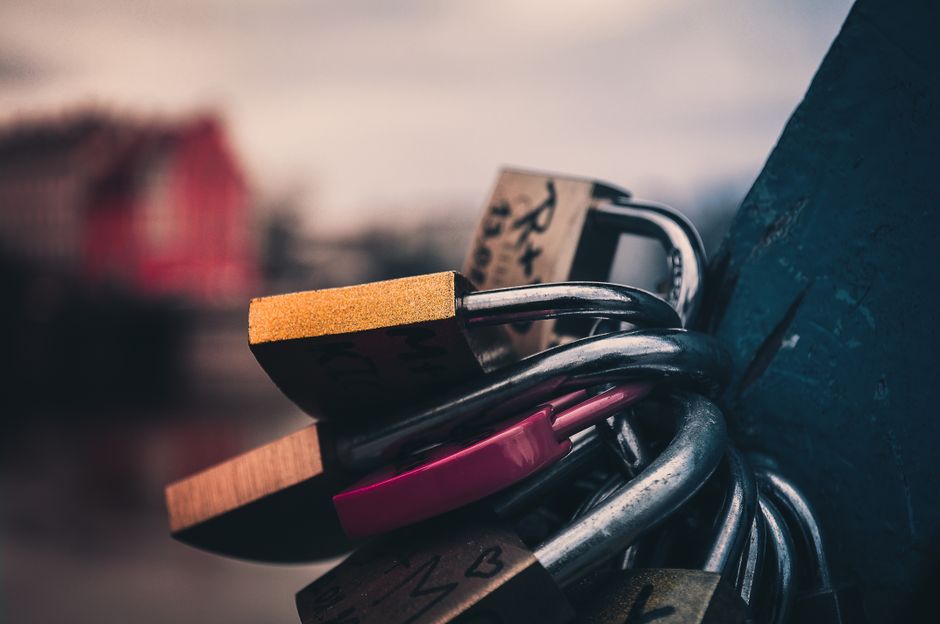 Close-up of love padlocks clinging to a bridge in Wrocław, symbolizing romantic bonds.