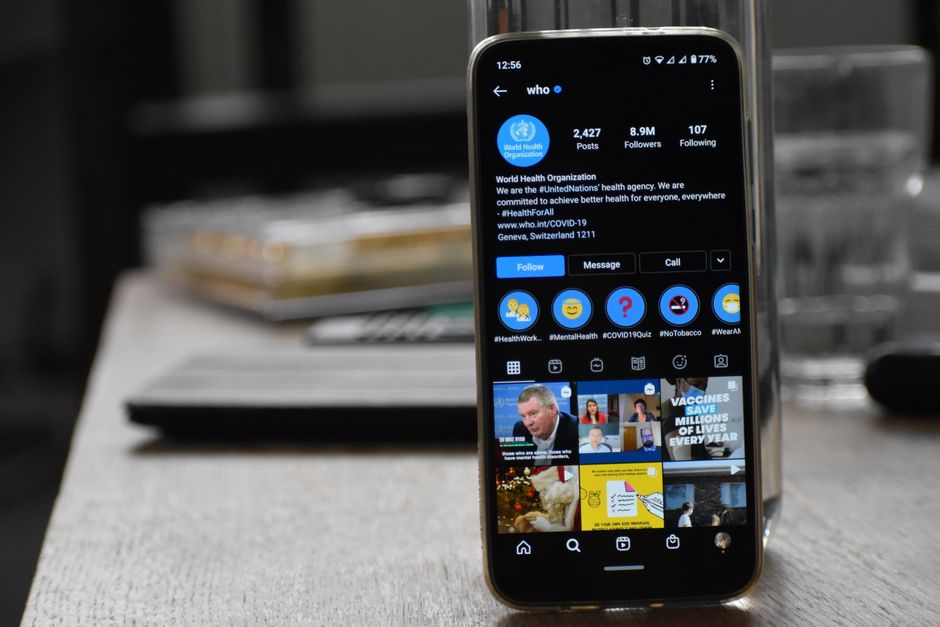 Close-up of a smartphone showing World Health Organization's Instagram profile indoors.